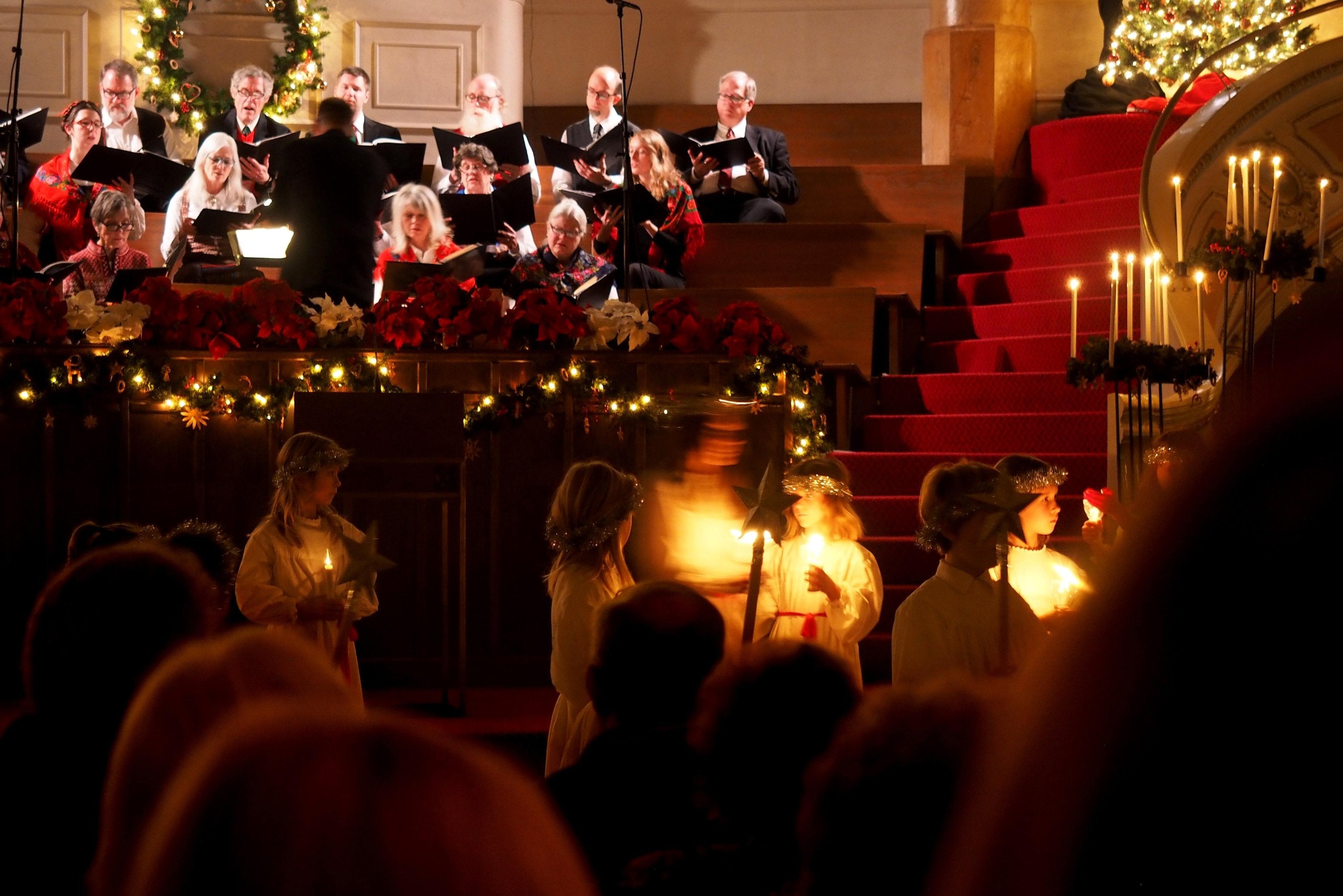 Congregation members worshiping and watching a choir perform in a church